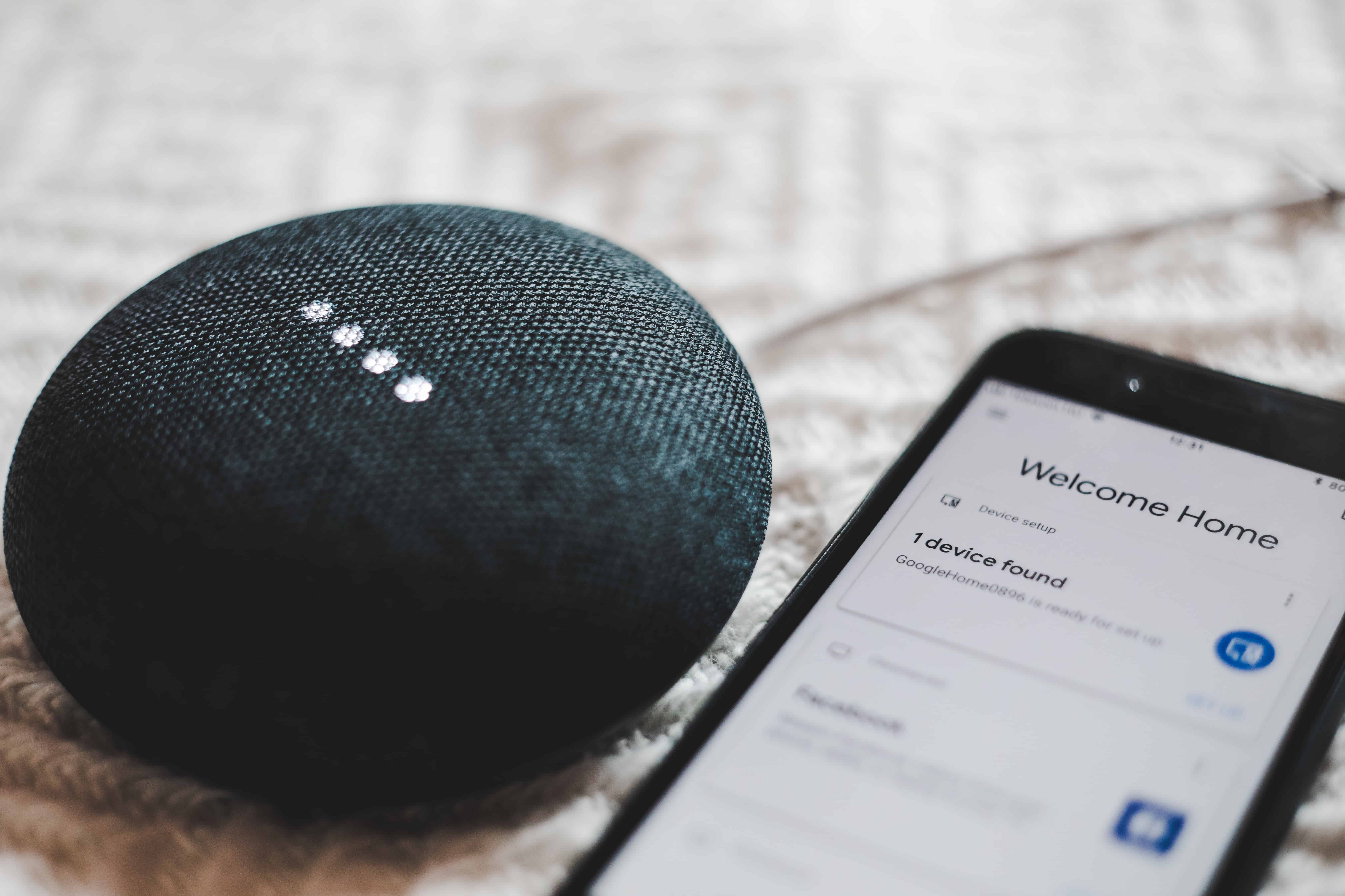 google home device beside smartphone